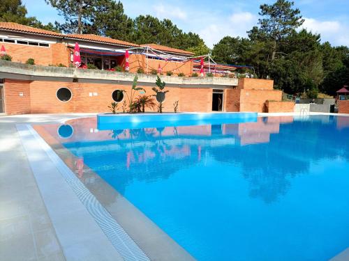 una grande piscina blu accanto a un edificio di Parque de Campismo Orbitur Foz de Arelho. a Foz do Arelho