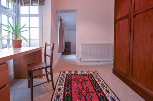 a room with a table and a chair and a rug at Quiet & Cosy Countryside Haven - Free parking in Weston