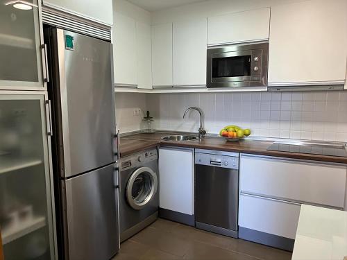 a kitchen with a stainless steel refrigerator and a dishwasher at Bella ÁGUILAS - Excelente ubicación en Las Delicias, vistas al mar, Wifi y Parking gratis in Águilas