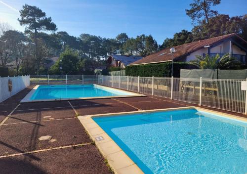 une piscine dans une cour clôturée dans l'établissement LES ESTIVALES - Maison mitoyenne pour 4 personnes, à Capbreton