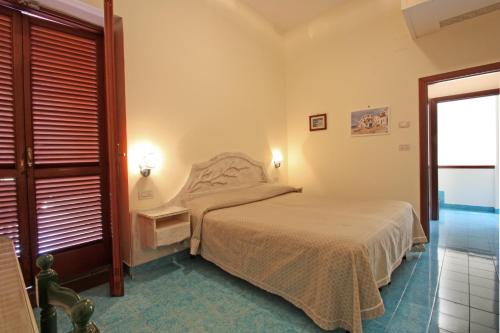 a small bedroom with a bed and a window at Hotel La Certosa in Massa Lubrense