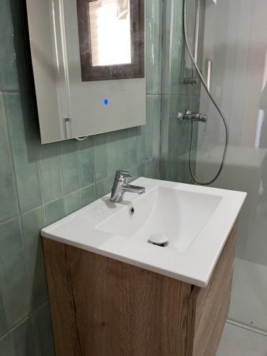 une salle de bain avec un lavabo blanc et une douche dans l'établissement Cap Blanc Apartment with Sea View and Beach, à Cullera