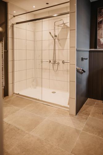 a bathroom with a shower with a glass door at The Murray Arms - Award Winning Boutique Hotel in Gatehouse of Fleet