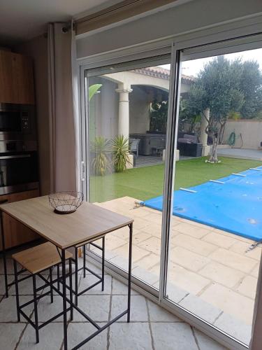 eine Küche mit einem Tisch und einer großen Glasschiebetür in der Unterkunft Studio bord de mer in Port-la-Nouvelle