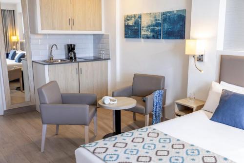a hotel room with a bed and a kitchen at Grupotel Alcudia Pins in Playa de Muro