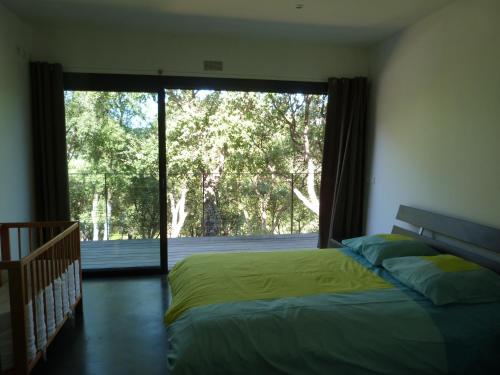 une chambre avec un lit et une grande fenêtre dans l'établissement Villa Suberaie, au Plan-de-la-Tour