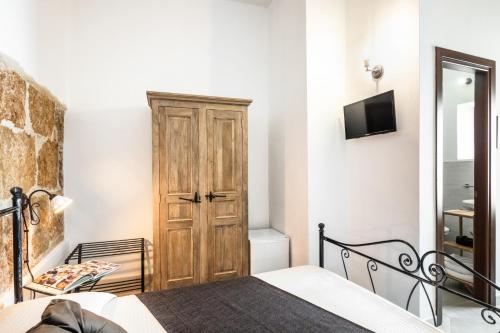 a bedroom with a bed and a tv on a wall at Morfeo Charming Rooms & Relax in Avola