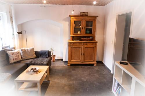 a living room with a couch and a wooden cabinet at Ferienwohnung Sonnenuhr in Brauneberg