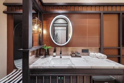 a bathroom with a sink and a mirror at Yinzhuo Hotel - New Chinese decoration, free late-night supplies, free fruit, water and free snacks, close to the International Convention and Exhibition Center, Embassy, Sanlitun, Bird's Nest, close to Sanyuan Bridge of Metro Line 10 and Airport Line in Beijing