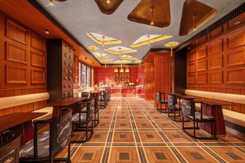 a restaurant with tables and chairs and a bar at Yinzhuo Hotel - New Chinese decoration, free late-night supplies, free fruit, water and free snacks, close to the International Convention and Exhibition Center, Embassy, Sanlitun, Bird's Nest, close to Sanyuan Bridge of Metro Line 10 and Airport Line in Beijing