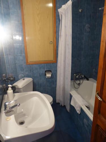 a bathroom with a sink and a toilet and a tub at Casa Adelina in Morella