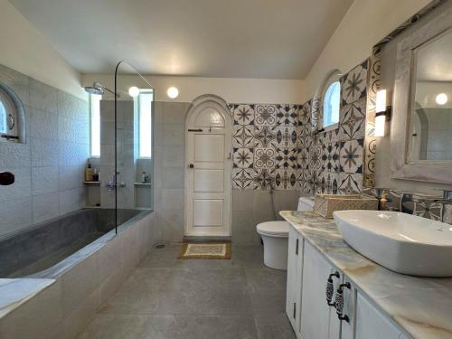 a bathroom with a sink and a tub and a toilet at The Propeller a Luxury Farmstay at Crossroads Getaway in Denkanikota