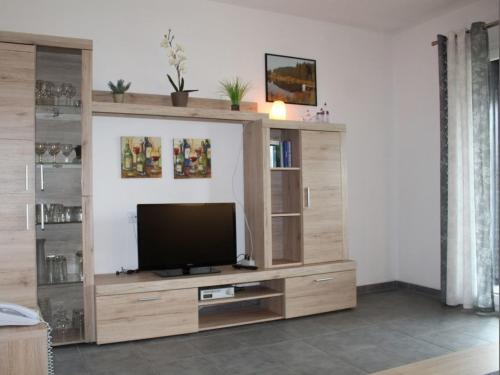 a large wooden entertainment center with a flat screen tv at Ferienhaus Nr 3, Kategorie Komfort, Feriendorf Hochbergle, Allgäu in Lechbruck