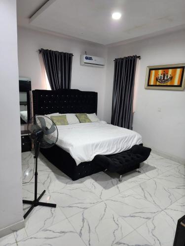 a bedroom with a bed with a marble floor at Laribond's Place Magodo Lagos in Magodo
