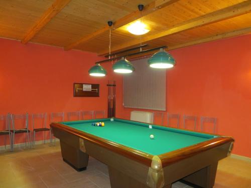 a pool table in a room with red walls and lights at Casale delle Lucrezie by VacaVilla in Due Santi