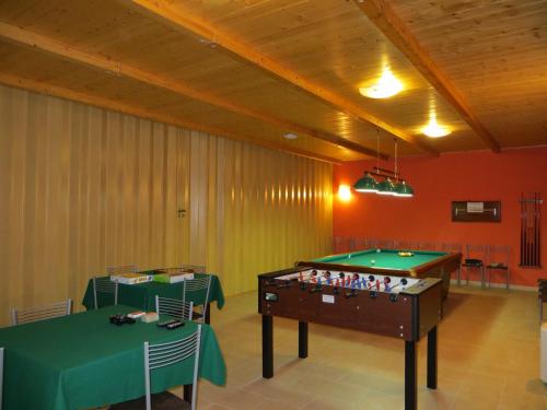 a room with a pool table and two tables at Casale delle Lucrezie by VacaVilla in Due Santi