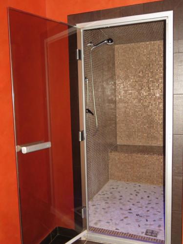 a shower with a glass enclosure in a bathroom at Casale delle Lucrezie by VacaVilla in Due Santi