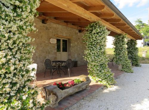 a patio with a table and a bunch of flowers at Casale delle Lucrezie by VacaVilla in Due Santi