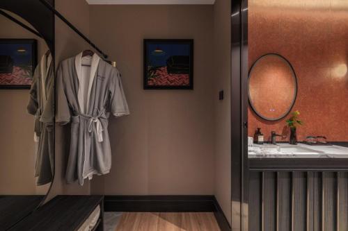 a bathroom with a sink and a robe hanging on a wall at Yinzhuo Hotel - New Chinese decoration, free late-night supplies, free fruit, water and free snacks, close to the International Convention and Exhibition Center, Embassy, Sanlitun, Bird's Nest, close to Sanyuan Bridge of Metro Line 10 and Airport Line in Beijing