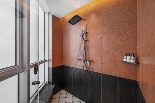 a bathroom with a shower with brown walls at Yinzhuo Hotel - New Chinese decoration, free late-night supplies, free fruit, water and free snacks, close to the International Convention and Exhibition Center, Embassy, Sanlitun, Bird's Nest, close to Sanyuan Bridge of Metro Line 10 and Airport Line in Beijing