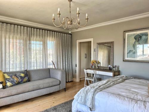 a bedroom with a couch and a table and a desk at SandDollar - Entire house in Cape St Francis