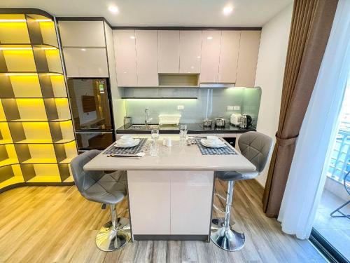a kitchen with a white island in a room at Hibiki Apartment in Hanoi