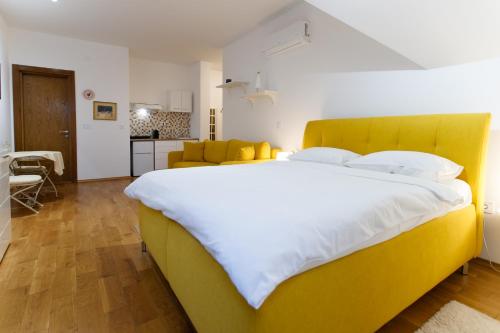 a large bed with a yellow headboard in a bedroom at JEZERSKA RESIDENCE Palić in Palić