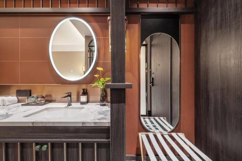 a bathroom with a sink and a mirror at Yinzhuo Hotel - New Chinese decoration, free late-night supplies, free fruit, water and free snacks, close to the International Convention and Exhibition Center, Embassy, Sanlitun, Bird's Nest, close to Sanyuan Bridge of Metro Line 10 and Airport Line in Beijing