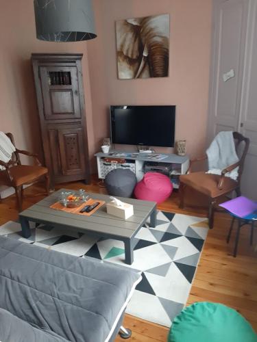 un salon avec une table et une télévision dans l'établissement Gîte sur St Pol sur mer de 2 à 8 couchages, à Saint-Pol-sur-Mer