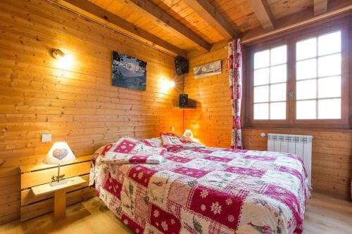 une chambre avec un lit dans une cabane en bois dans l'établissement Chalet spacieux à Saint-Gervais-les-Bains avec vue montagne, à Saint-Gervais-les-Bains