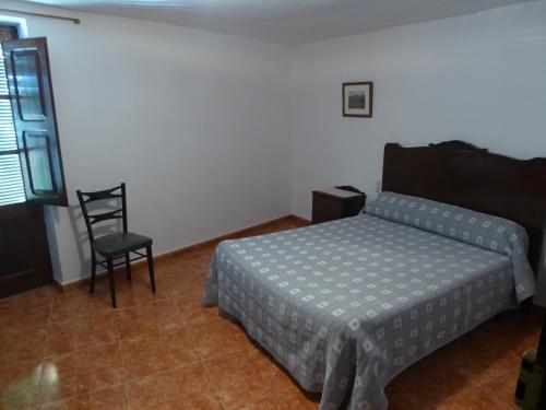 a bedroom with a bed and a chair at Casa Adelina in Morella
