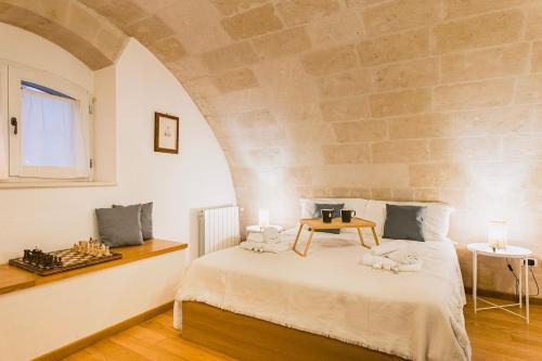 a bedroom with a bed with a stone wall at Sassi Suite - Elegant Historic Home in Matera