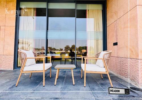 two chairs and a table in front of a building at Kavyum Retreat in Himatnagar