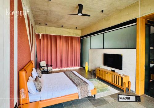 a bedroom with a bed and a flat screen tv at Kavyum Retreat in Himatnagar