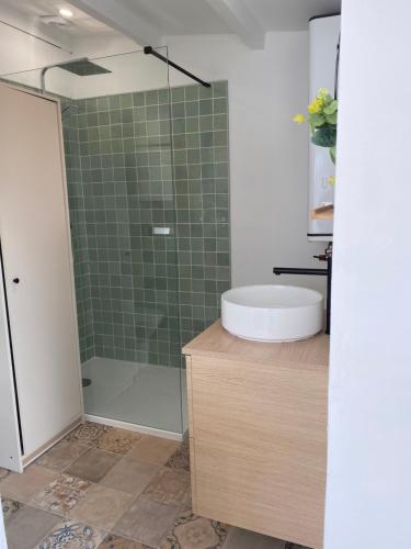 a bathroom with a shower and a sink and a tub at Hameau au cœur de la forêt in Herm
