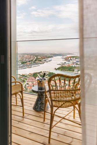 a balcony with a table and chairs and a view of a river at Clarion Hotel Karlatornet in Gothenburg