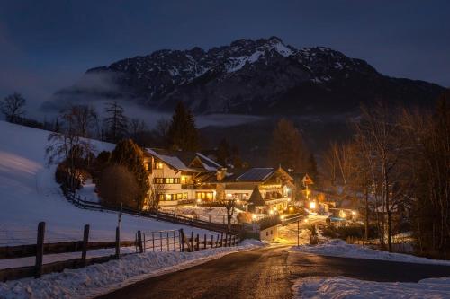 a house in the snow at night with a mountain at Landhaus St. Georg in Gröbming