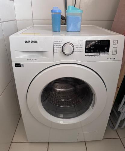 a washing machine with two cups on top of it at Apê Central Bonito in Bonito