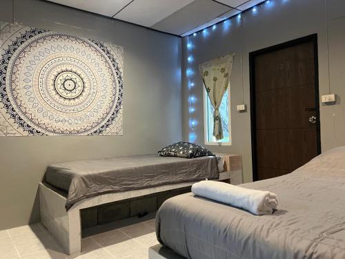 a bedroom with two beds and a painting on the wall at Jungle Retreat Apartment in Chaloklum