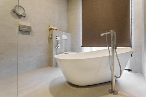 a large white bath tub in a bathroom at Castel Mimi Wine Resort in Bulboaca