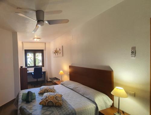 a bedroom with a bed and a desk and a window at Bella ÁGUILAS - Excelente ubicación en Las Delicias, vistas al mar, Wifi y Parking gratis in Águilas