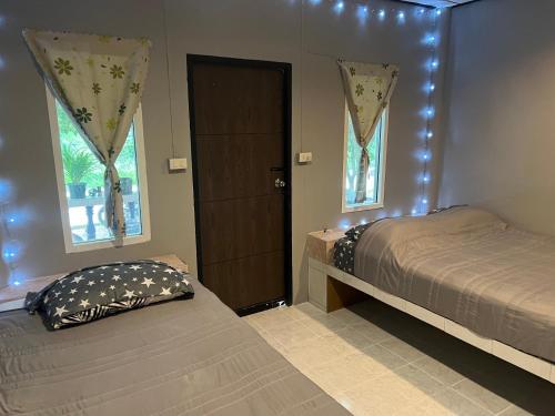a bedroom with two beds and a door with windows at Jungle Retreat Apartment in Chaloklum