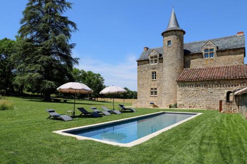 a pool in front of a building with chairs and umbrellas at Chateau de Cambayrac, résidence exceptionnelle pour 12 personnes in Castanet