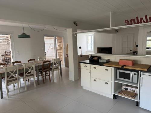 une cuisine et une salle à manger avec une table et des chaises dans l'établissement ღ La Passerelle, Spatieux Avec Jardin, au Bois-Plage-en-Ré