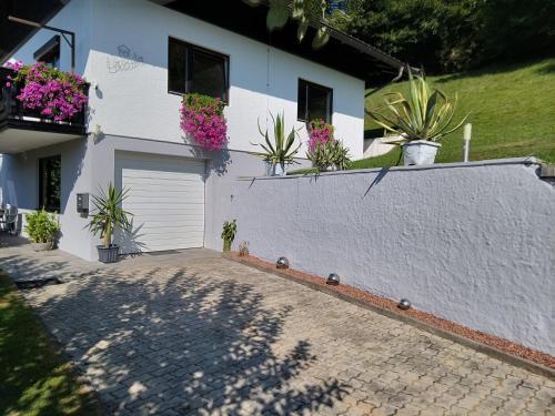 a white house with plants on the side of it at Ferienhaus Ursula Velden in Velden am Wörthersee