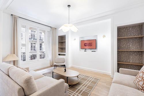 - un salon blanc avec un canapé et une chaise dans l'établissement GuestReady - Stylish Escape near Attractions, à Paris