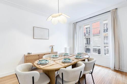 une salle à manger avec une table et des chaises en bois dans l'établissement GuestReady - Stylish Escape near Attractions, à Paris