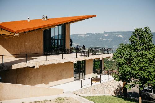 a building with a deck with tables and chairs at Apaga Resort in Ijevan