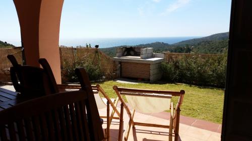 a view from a patio with a grill and chairs at Villa Eden Home Holiday in Santa Margherita di Pula