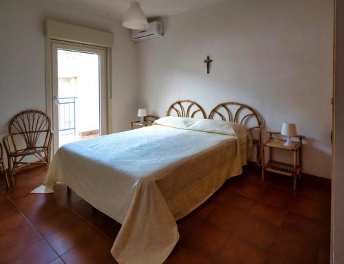 a bedroom with a bed with a cross on the wall at Taormina Sea house in SantʼAlessio Siculo